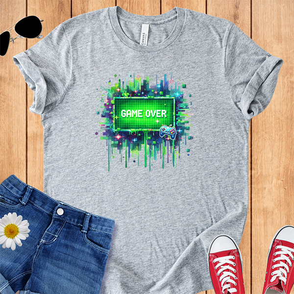 Gray t-shirt with 'Game Over' graphic  with pixel style video game screen on a wooden surface with jeans and sneakers.